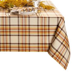 a plaid tablecloth with yellow flowers and silverware on it is set for an elegant dinner