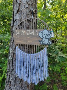 a wooden sign hanging from the side of a tree