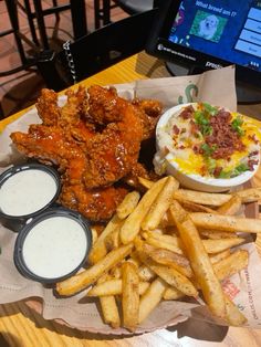 chicken wings, fries and coleslaw on a table