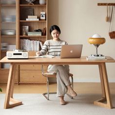 a woman sitting at a desk using a laptop computer