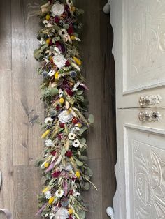 an arrangement of flowers is hanging on the wall