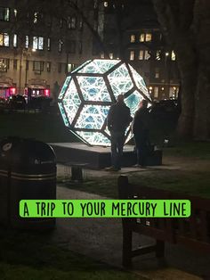 two people standing in front of a large light sculpture