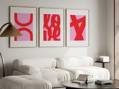 a living room filled with white furniture and two paintings on the wall above each couch