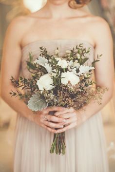 a woman holding a bouquet of flowers in her hands