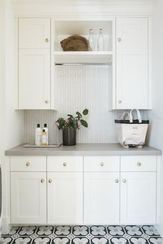 a kitchen with white cabinets and black and white floor tiles on the counter top, along with an instagram