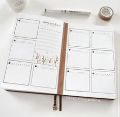 an open planner book sitting on top of a table