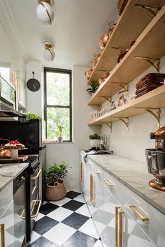 a kitchen with black and white checkered flooring, gold accents and open shelving