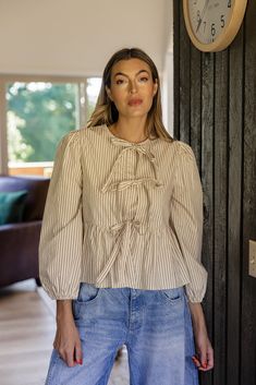 This girly stripe blouse features functional ties that fully open, a peplum silhouette, and balloon sleeves. We love this fun and flirty blouse for all those special occasions. functional ties unlined // paired with the free people good luck mid rise barrel jeans in lightblue Chic Puff Sleeve Top With Bishop Pleated Sleeves, Beige Puff Sleeve Blouse With Gathered Sleeves, Chic Lantern Sleeve Blouse With Pleated Details, Classic Button-up Blouse With Pleated Sleeves, Spring Pinstripe Button-up Blouse, Tie Blouse, Striped Blouse, Memory Lane, Free People