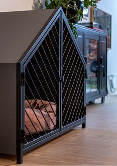 a dog house that is on the floor next to a potted plant in it