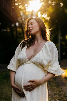 a pregnant woman poses for a photo in the sun