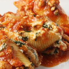 two stuffed cabbages covered in sauce on a white plate