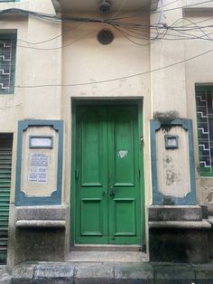 a green door on the side of a building