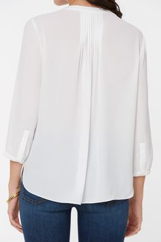 NYDJ's Pintuck Pleat Back Women's Blouse boasts a billowy long sleeve silhouette that's perfect when paired with any of our slimming Women's denim styles. Pleating at the back yoke creates a sophisticated yet easy drape. Split round neckline with covered full front placket and button closure. | NYDJ Women's Pintuck Blouse in Optic White, Regular, Size: Medium | Denim Elegant Half Sleeve Relaxed Fit Blouse, Daywear Tops With Blouson Sleeves And 3/4 Sleeve, Daywear Tops With Blouson 3/4 Sleeves, Chic Blouse For Casual Gatherings, Elegant Half Sleeve Relaxed Fit Top, Elegant Half Sleeve Blouse For Daywear, 3/4 Sleeve Relaxed Fit Blouse For Work, Chic Relaxed Fit Half Sleeve Blouse, Relaxed Fit Blouse With 3/4 Sleeves