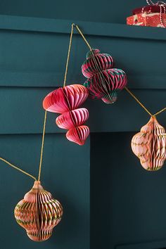 three paper lanterns hanging on a wall