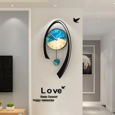 there is a clock on the wall in the living room that says love and has birds flying around it