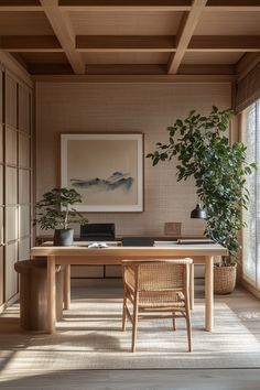 a room with a table, chair and potted plant