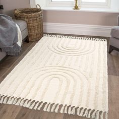 a white rug with fringes on the floor in front of a chair and window