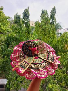 a person holding up a decorative item in their hand