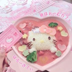 a hello kitty plate with broccoli and rice in it