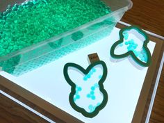 two cookie cutters sitting on top of a table next to green gummy balls