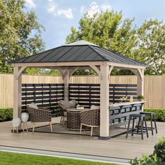 a gazebo sitting on top of a wooden deck next to a table and chairs