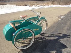 an old fashioned bicycle is parked on the side of the road in front of some snow