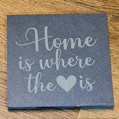 a slate coaster that says home is where the heart is