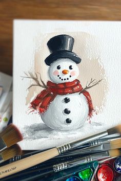 A hand-painted Christmas card featuring a snowman with a top hat and red scarf. Christmas Painting Snowman, Watercolor Christmas Snowman, Watercolor Snowmen Christmas Cards, Watercolor Art For Christmas, Christmas Paintings Snowman, Simple Snowman Painting, Cozy Christmas Painting, Christmas Card Painting Ideas Acrylic, Hand Painted Snowman