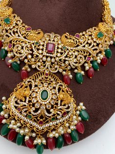 Red Green Stone Peacock Red Green beads Ethnic Necklace with Matching Screwback EarringsColor : GoldenSize : Necklace Length : 16 Inches; Earring Length : 2.5 InchesStones : Red Green Stone CZ pearls Red Green Beads Traditional Festival Earrings With Stones, Traditional Bridal Necklace With Stones, Red Jewelry With Peacock Design For Diwali, Red Jeweled Jewelry For Diwali, Traditional Bridal Necklace With Stones For Festivals, Red Temple Necklace With Stone Work For Festivals, Red Peacock Design Jewelry For Wedding, Festive Red Jewelry With Peacock Design, Red Bohemian Kundan Necklace For Diwali