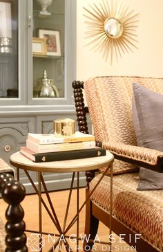 a living room with a chair, table and books on it