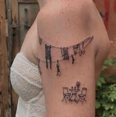 a woman with a tattoo on her arm that has clothes hanging out to dry off