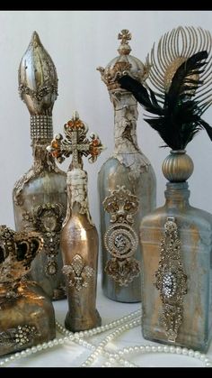 an assortment of decorative vases and other items on a white tablecloth with pearls