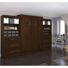 a large wooden cabinet with drawers in the middle of a room next to a staircase