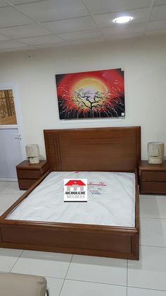 a bed room with a neatly made bed and two night stands on the floor next to it