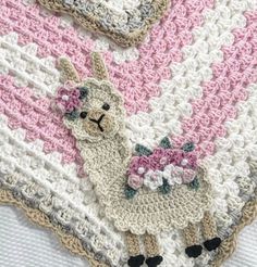 a crocheted blanket with an alpaca and flowers on the bottom is shown