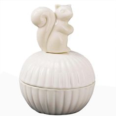 a white ceramic container with a squirrel on top