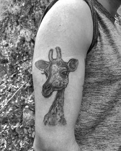 a black and white photo of a giraffe's head on a man's arm