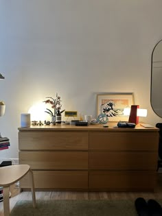 a room with a dresser, mirror and various items on the table in front of it