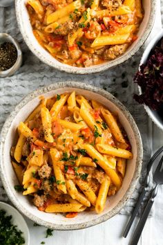 two bowls filled with pasta and meat sauce