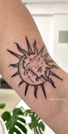 a sun and moon tattoo on the arm