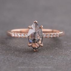 an engagement ring with a pear shaped brown diamond surrounded by small white and yellow diamonds