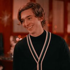 a young man smiling and wearing a black sweater