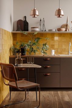 a kitchen with wooden flooring and brown cabinetry next to a dining room table