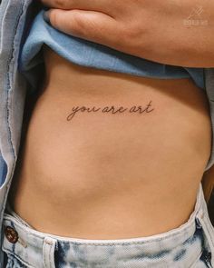 a woman's stomach with the words you are art written on it