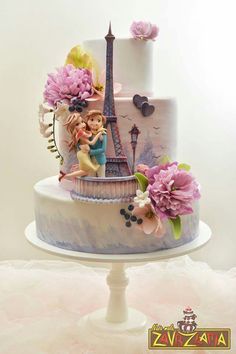 a three tiered cake decorated with figurines and flowers