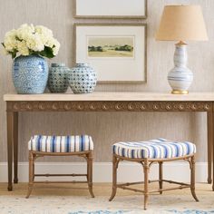 two blue and white vases sitting on top of a table next to a bench