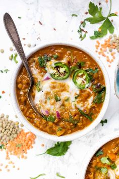 two bowls filled with lentula soup and topped with sour cream, cilantro