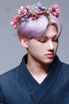 a man with purple hair wearing a flower crown