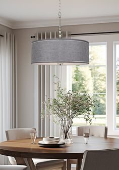 a dining room table with chairs and a vase on it next to a large window