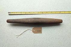 an old wooden object with a ruler next to it